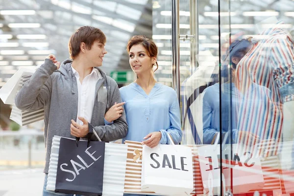 Young Affectionate Couple Paperbags Discussing New Purchase While Walking Window — Stock Photo, Image