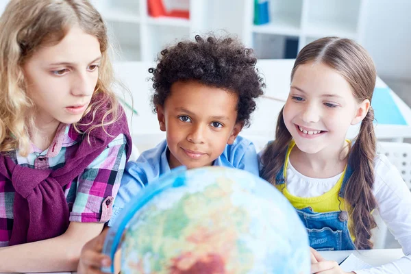 Bonitos Colegas Classe Olhando Modelo Globo Enquanto Estudam Países Terras — Fotografia de Stock