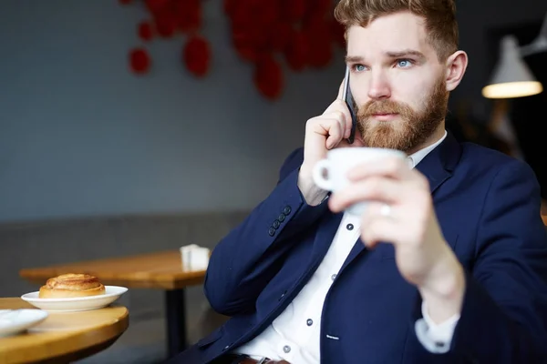 Yakışıklı Genç Işadamı Smartphone Kafede Kahve Fincanı Holding Tarafından Konuşan — Stok fotoğraf