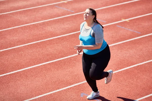 非常疲乏的肥胖少妇有心脏训练在热的天气在体育场 — 图库照片