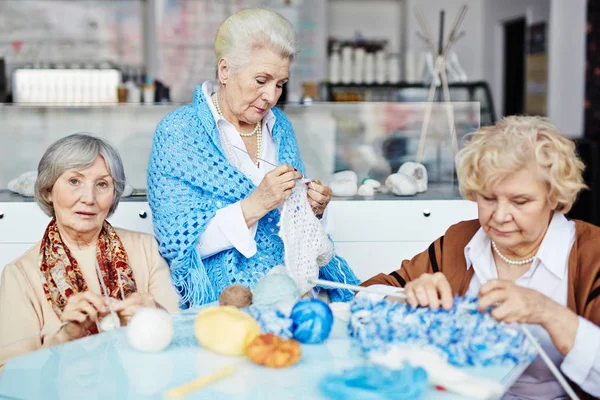 三漂亮的老年妇女聚集在客厅里 热情地为家人织暖和的衣服 — 图库照片