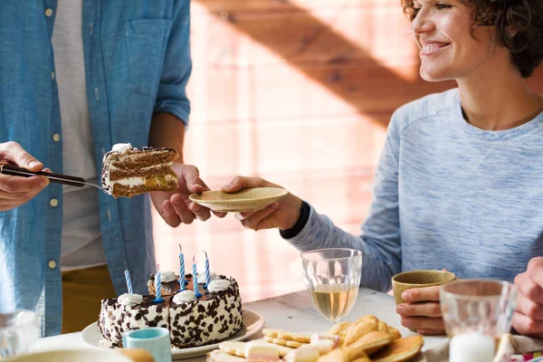 Szczęśliwa Młoda Kobieta Biorąc Kawałek Tortu Urodzinowego Przez Świąteczny Stół — Zdjęcie stockowe