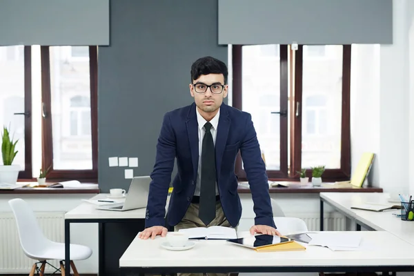 Jovem Empresário Confiante Óculos Inclinado Mesa Enquanto Posando Para Fotografia — Fotografia de Stock