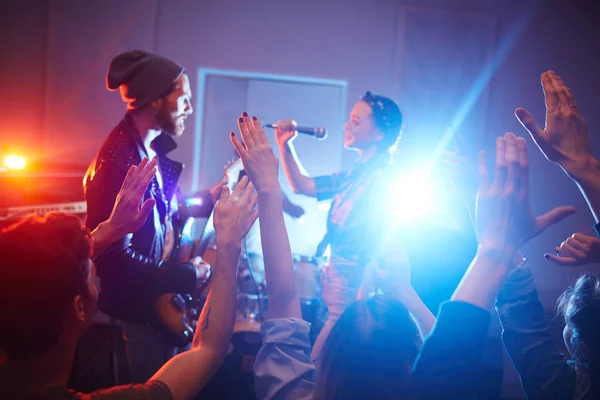 地方摇滚乐队表演音乐在城市俱乐部的阶段与人群欢呼和跳舞的人聚会 — 图库照片