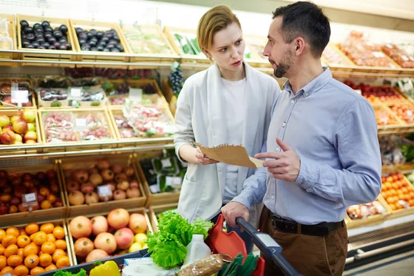 成人情侣在超市买杂货时的购物清单争论 — 图库照片