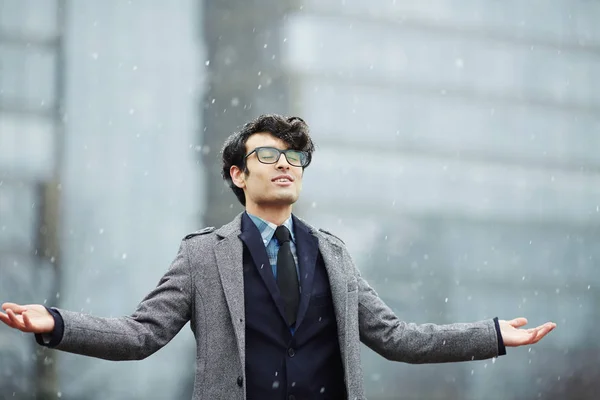 若いハンサムな中東のビジネスマン冬の街を楽しむ散歩を笑って 目を閉じて 冷たい雪を感じの肖像画 — ストック写真
