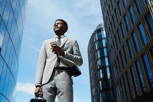 Urban businessman with briefcase and smartphone