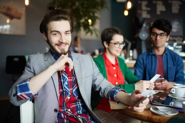 三具创意的人身着商务休闲的肖像在咖啡馆的餐桌上 专注于年轻的微笑商人与长发微笑乐呵呵地看着相机 — 图库照片