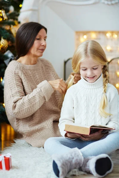 Malá Holčička Čtení Knihy Zatímco Babička Úplety Její Ocásek Vánoce — Stock fotografie