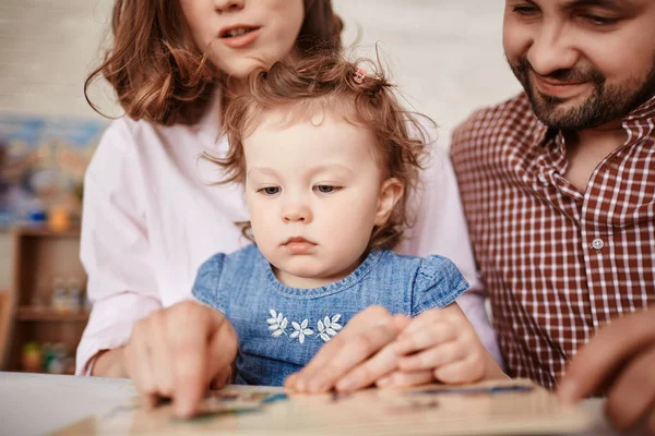 Cute Little Girl, patrząc na zdjęcia w książeczka — Zdjęcie stockowe