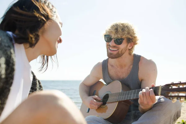 Mutlu Adam Gitar Çalmak Arkadaşı Ile Deniz Kenarında Sıcak Güneşli — Stok fotoğraf