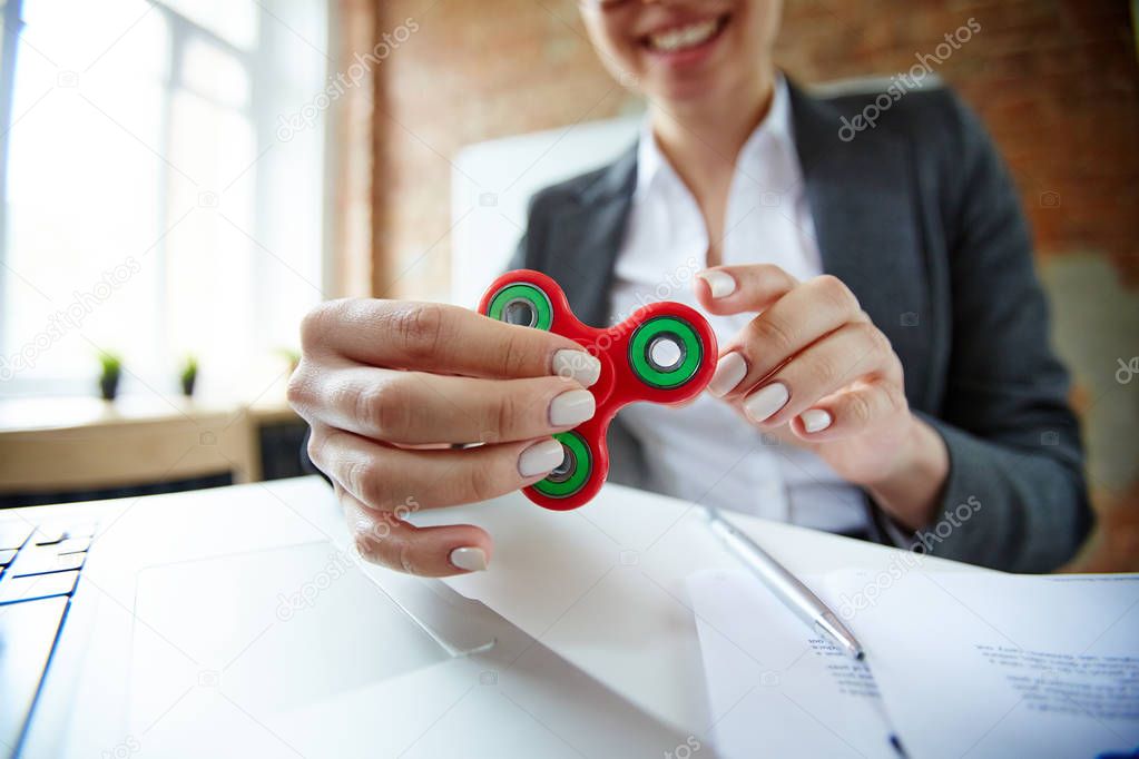 Businesswoman with fidget spinner having anti-stress timeout