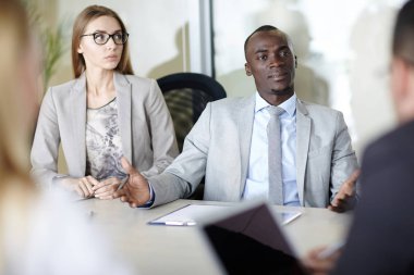 Grup konsantre meslektaşlarının modern yönetim kurulu odası masada otururken ortak proje üzerinde beyin fırtınası
