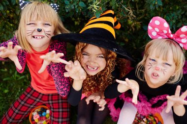 Scary halloween girls in costumes trying to frighten you clipart