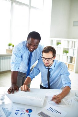 Ofis Masası ayakta ve erkek meslektaşı bilgisayar programı prensibi işletim açıklayan orta yaşlı Afro-Amerikan çalışan