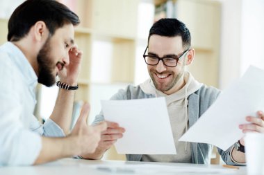 Modern güneşli ofiste toplantı ve gülümseyerek belgelerle çalışma iki orta yaşlı arkadaşları portresi