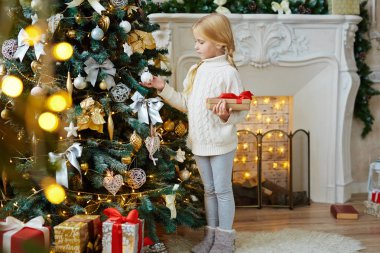 Şirin çocuk tarafından dekore edilmiş firtree ve şömine homewear ayakta xmas gecesi