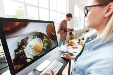 Bilgisayar monitörü üretim Studio önünde oturan profesyonel gıda Tasarımcısı