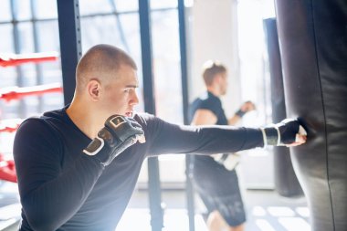 Yan görünümü kum torbası içinde güneşli mücadele clu isabet genç kas boksör portresi