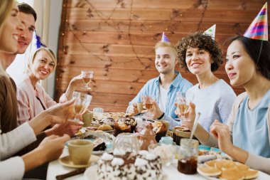 Doğum günü kapaklar ile tezahürat genç insanlar içecekler içinde kadehlerin tarafından Festival tablo