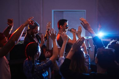 Yakışıklı müzisyenler ile tezahürat ve dans kalabalık kentsel club sahnede sallanan parti yükselterek silah insanlar