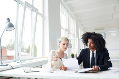 İki genç bankacılar kağıtları office toplantıda tartışılması