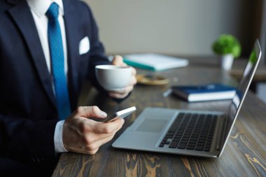 Kafede çalışan tanınmaz zarif işadamı portresi portre: smartphone kullanarak ve kahve içme