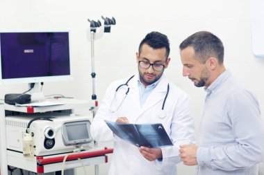 Hasta ve doktor diz x-ray arıyorsunuz klinik ofiste neden