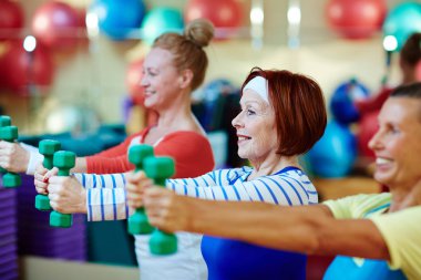 Enerjik kadın dumbbells ile egzersiz yaparken kol germe
