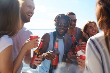 Büyük grup arkadaşları ile deniz kenarında boş zaman harcama içecekler