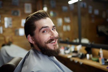 Kameraya bakarak temiz saç modeli ile gülümseyen adam