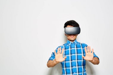 Genç adam ekose desenli gömlek eğleniyor Vr kulaklık, atış studio yardımıyla sanal gerçeklik yaşıyor