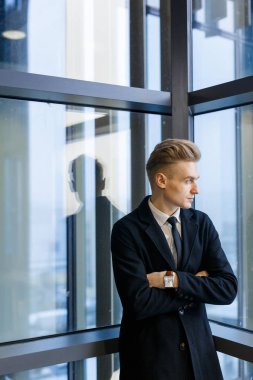 Ofis koridorunda, bel, dikey düşünceli işadamı duran kolları olan pencere bakarak takım elbise çapraz