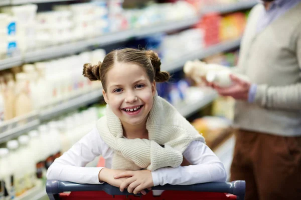开朗的女孩在她父亲的背景下看着在超市的摄像头 — 图库照片