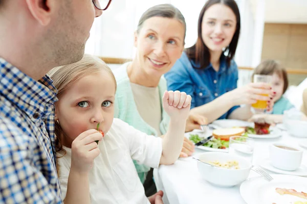 Ragazzina Mangiare Guardando Fotocamera Durante Cena Famiglia — Foto Stock