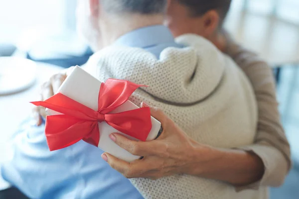 Mano Mujer Sosteniendo Caja Regalo Mientras Abraza Marido — Foto de Stock