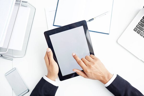 Businessman pointing at touchscreen of tablet during presentation