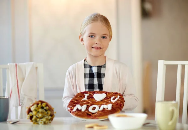 母が台所でカメラ目線の焼かれたパイと幸せな女の子 — ストック写真