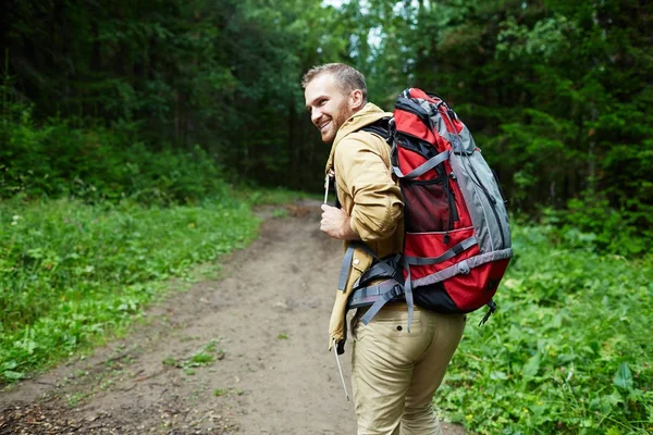 Jovem Feliz Com Mochila Olhando Para Trás Enquanto Caminhadas — Fotografia de Stock