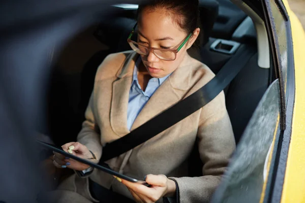 手机女商人与触摸板工作在出租车驾驶室在线 — 图库照片
