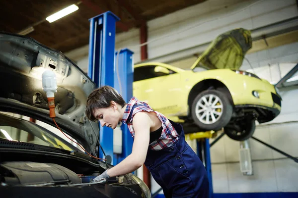 Young woman working in garage or car service center