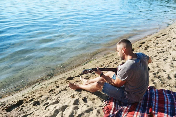 Jongeman Gitaarspelen Terwijl Ontspant Het Zandstrand — Stockfoto