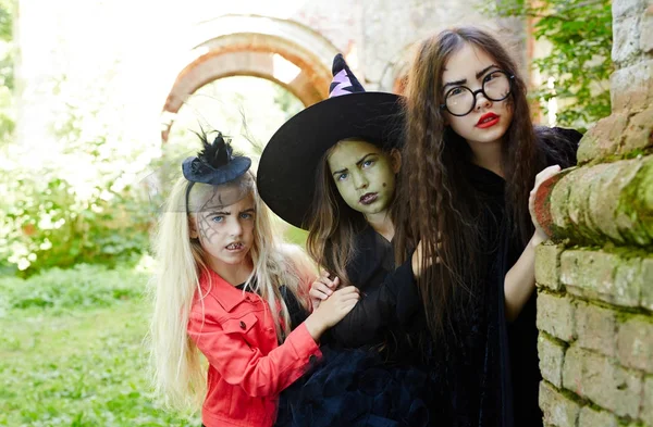 Drie Langharige Halloween Meisjes Gluren Uit Hoek Van Verwaarloosde Gebouw — Stockfoto