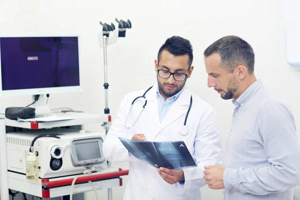 Ασθενής Και Γιατρός Βλέπει Ακτινογραφία Γόνατος Οδηγήσει Κλινικά Γραφείο — Φωτογραφία Αρχείου