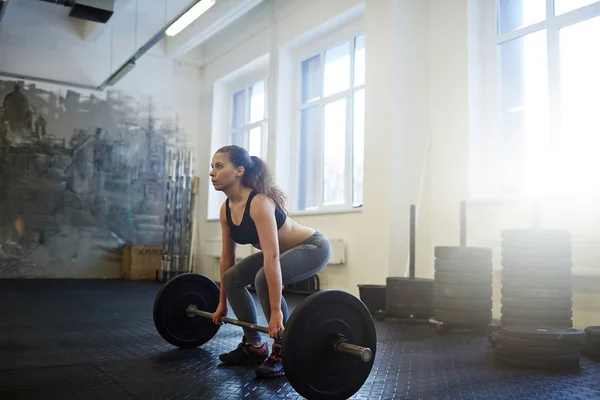 Strong young woman practicing weightlifting