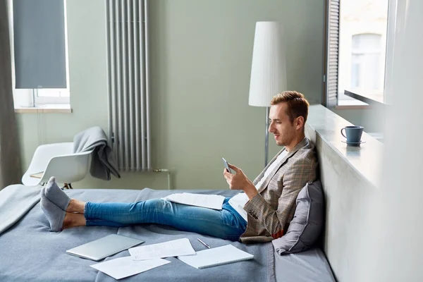 Profile View Smiling Young Freelancer Texting His Colleague Smartphone While — Stock Photo, Image