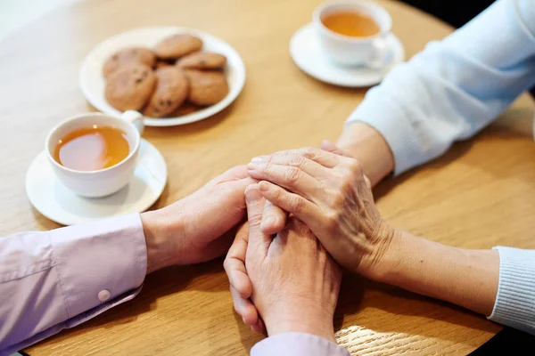 Händerna Senior Par Träbord Med Koppar Och Mellanmål Nära — Stockfoto