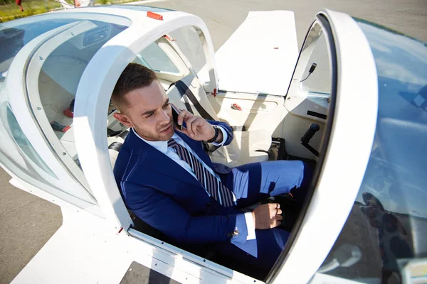 高速なビジネス旅行の概念 ジェット機で電話で話すビジネスマンの高角度 — ストック写真