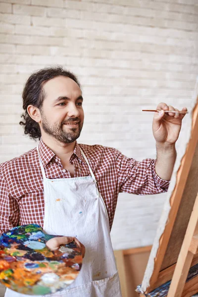 油の色のパレットを保持しているワーク ショップは イーゼルに絵を描いている風の才能のあるアーティストの肖像画 — ストック写真