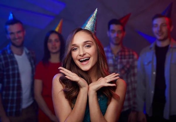 愉快的女孩在生日帽子在她的朋友背景 — 图库照片